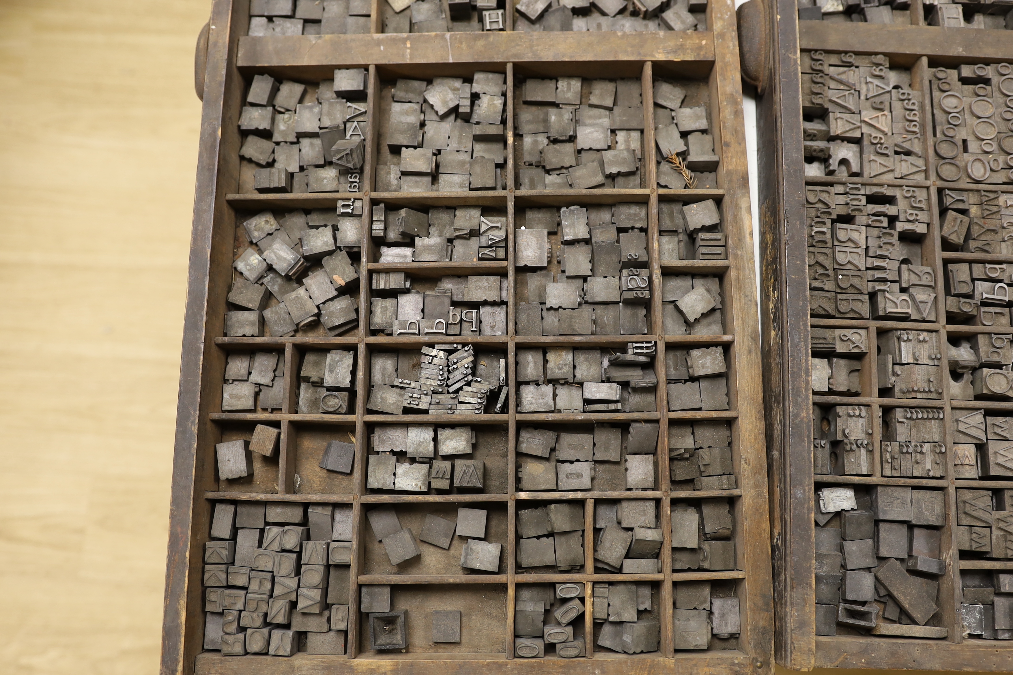 Three trays of metal printing type: chases, quoins and spacing bars